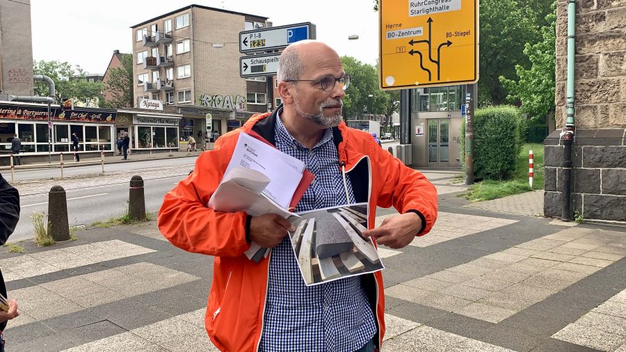 Christoph Matten präsentiert für die Hattinger Straße den neuen Trennstein zur Abgrenzung des Radstreifens
